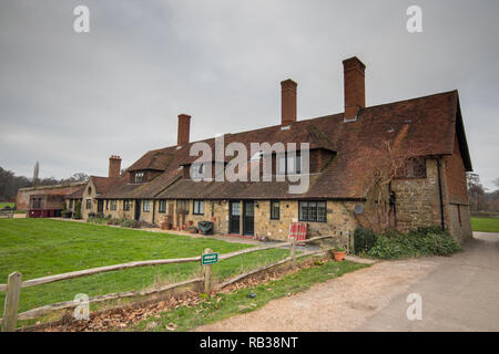 Cottages oltre le rovine di Cowdray House, Midhurst, West Sussex, Regno Unito Foto Stock