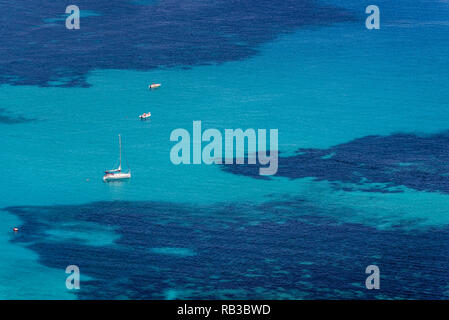 Vista aerea di tropicale mare blu turchese con galleggiante di barche e persone. Barche a vela ancorata accanto al reef intorno alla costa. Colpo d'occhio. Foto Stock