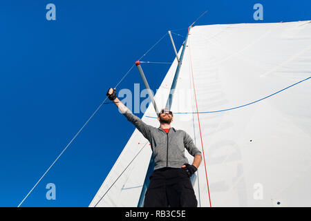 Fiducioso il capitano della barca vela in piedi e guardando il mare Foto Stock