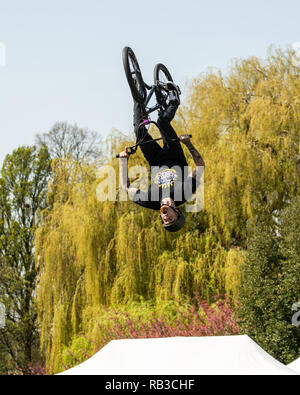 BMX trick ciclista metà capriola, alto in aria, effettuando in corrispondenza di una fiera di paese Foto Stock