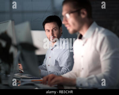 Close up.due colleghi un lavoro notturno in ufficio. Foto Stock