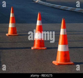 Arancione coni di sicurezza su asfalto Foto Stock