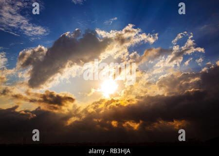 Raggi del sole al tramonto tra le nuvole prima della tempesta sulla città silhouette. Istanbul - Turchia Foto Stock