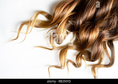 Pezzo di balayage marrone curly lucida i capelli bianchi su sfondo isolato Foto Stock