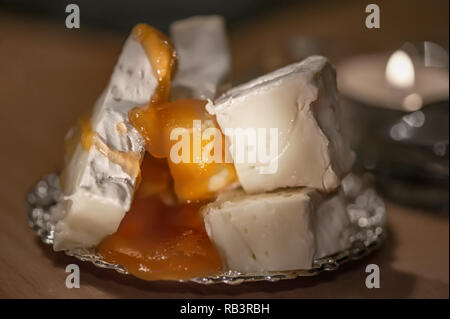 Camembert cremoso con miele su un rustico sfondo di legno. Close-up shot dettagliati. Foto Stock