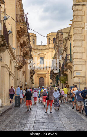 Noto, Sicilia, Italia - 23 agosto 2017: Visita turistica pittoresca via Corrado Nicolaci street con i caratteristici balconi Foto Stock