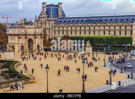 Parigi, Francia - 25 Ottobre 2013: i turisti a piedi nella parte anteriore del famoso Museo del Louvre, uno dei più grandi del mondo i musei di arte e di uno storico monumen Foto Stock