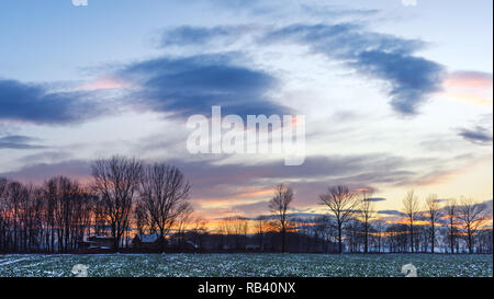 Rurale scena sul campo invernale i raggi del sole al tramonto. Fotografia di paesaggi Foto Stock