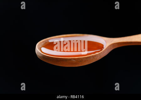 Un cucchiaio di legno riempita con fresco e fragrante miele. Close-up. Macro. Foto Stock