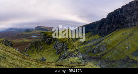 Singolo escursionista sulla cima della montagna in robusto paesaggio vulcanico intorno Quiraing, Isola di Skye in Scozia Foto Stock