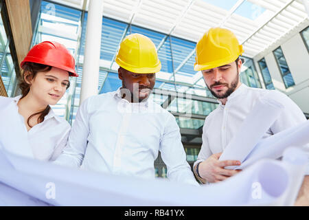 Tre ingegneri e architetti come un team nella costruzione di una riunione di pianificazione Foto Stock