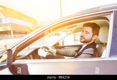 Imprenditore guida in auto con le mani sul volante Foto Stock