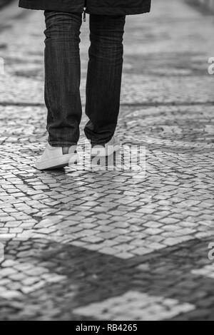 Foto in bianco e nero di gambe umane sul marciapiede, Lisbona, Portogallo Foto Stock
