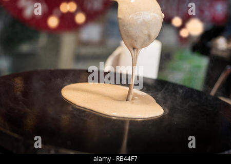 La cottura di una crêpe francesi al mercatino di Natale Foto Stock