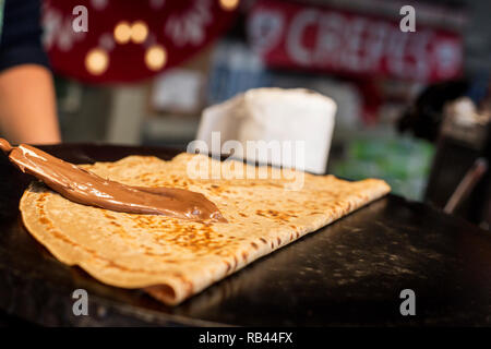 La cottura di una crêpe francesi al mercatino di Natale Foto Stock