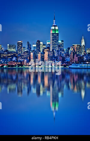 Skyline di New York con acqua riflessioni a notte Foto Stock