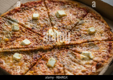 Quattro fette di pizza di formaggio in scatola di cartone. Close up foto. Foto Stock