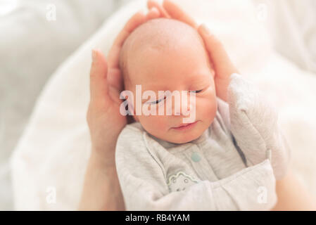 Baby nelle mani della mamma di close-up. Foto Stock
