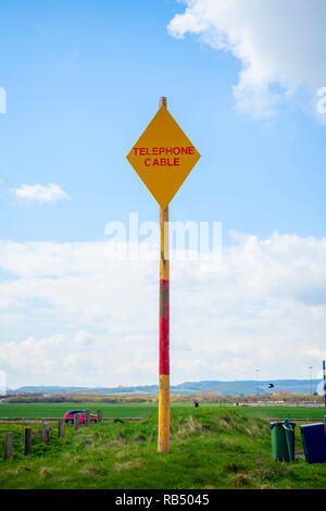 Un indicatore giallo o segno di avvertimento per la spedizione sulla costa nord est dell' Inghilterra vicino Redcar, per contrassegnare la posizione in cui sottomarino cavo telefonico viene a riva. Foto Stock