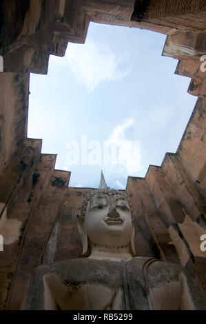 Basso angolo vista della bella pietra statua del Buddha di Wat Si Chum in Sukhothai il parco storico, Thailandia Foto Stock