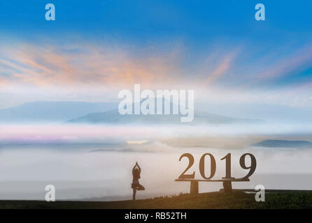 La silhouette di astratta del 2019 con la donna stand esercizio yoga, il bellissimo cielo cloud Thailandia Fuji mountain view da parte del fascio di luce e lens flare FEP Foto Stock