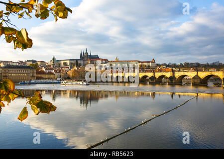 Praga con Charles ponte attraverso il fiume Vltava e il castello di Hradcany complesso in golden colori autunnali. Viaggi, vacanze e visite turistiche concetto con negativo Foto Stock