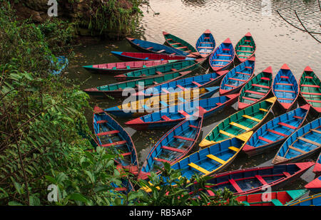 Barche in fewa lake in Pokhara, Nepal presso sunrise prima di andare via per il giorno. Foto Stock