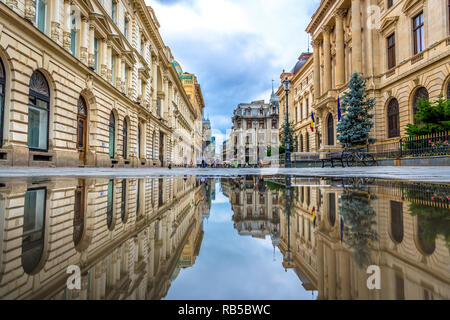 Bucarest, Romania - 6 Luglio 2018 - La città vecchia di Bucarest visto attraverso una riflessione di acqua con persone in background in Romania Foto Stock