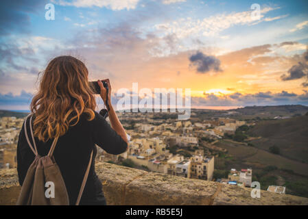 Ragazza turistica di scattare le foto di una splendida vista dalla cima di un castello medievale, Gozo Malta Foto Stock