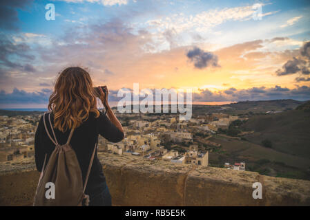 Ragazza turistica di scattare le foto di una splendida vista dalla cima di un castello medievale, Gozo Malta Foto Stock