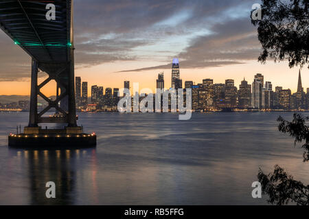 Sotto il ponte. Inverno crepuscolo sopra il ponte della baia e la skyline di San Francisco. Foto Stock
