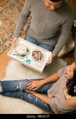 Chiusura del giovane con cioccolata calda a casa Foto Stock