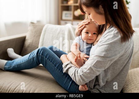 Felice madre con bambino più piccolo figlio a casa Foto Stock