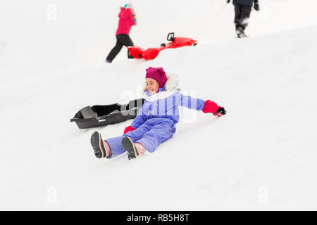 I bambini con slittini sulla collina di neve in inverno Foto Stock