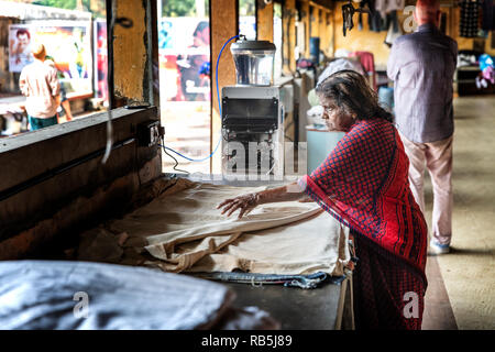 Cochin, Kerala, India : 25 Dicembre 2018 : vecchia donna indiana sta lavorando in un tradizionale servizio lavanderia in Cochin, Kerala, India. Foto Stock