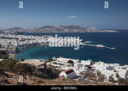 Vista panoramica della città di Mykonos harbour con famosi mulini a vento dalle colline sopra su una soleggiata giornata estiva, Mykonos, Cicladi Grecia Foto Stock