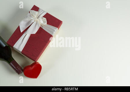 Bottiglia di vino con il regalo di San Valentino e la decorazione su sfondo bianco Foto Stock