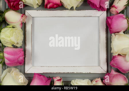 Svuotare il photo frame circondato con fiore rosa Foto Stock