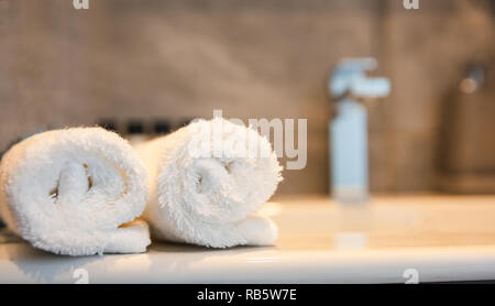 Bagno interno. Dissipatore di sfocatura e il rullo bianco di ups di asciugamani. Primo piano con i dettagli Foto Stock