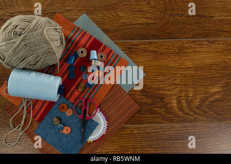 Tessile, rulli di filettatura e varie attrezzature su un tavolo Foto Stock