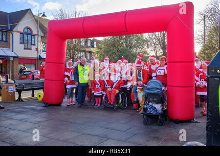 I partecipanti vestiti da Babbo Natale che prendono parte alla grande Thatcham Santa Fun Run in attesa all'inizio per l'evento per iniziare, Thatcham, Regno Unito Foto Stock