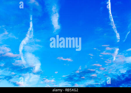 Modello di colore blu scuro, rosa e bianco delle nuvole, aereo sentieri sul cielo blu Foto Stock