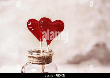 Il giorno di san valentino, dolciumi e concetto romantico - rosso a forma di cuore lecca lecca su sfondo bianco Foto Stock