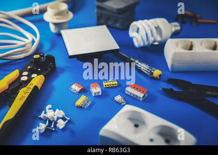 Impianto elettrico - elettricista strumenti e apparecchiature su sfondo blu Foto Stock