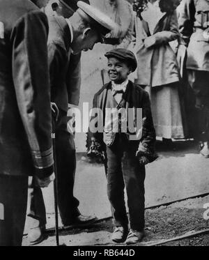 Fotografia di Re Giorgio V (1865 - 1936) re del Regno Unito e i domini britannici e Imperatore dell'India. King George risponde con un bambino lavoratore nel corso della sua visita a Sunderland. Datata 1918 Foto Stock