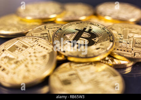 Pila di bitcoins giacente sulla lucida superficie scura Foto Stock