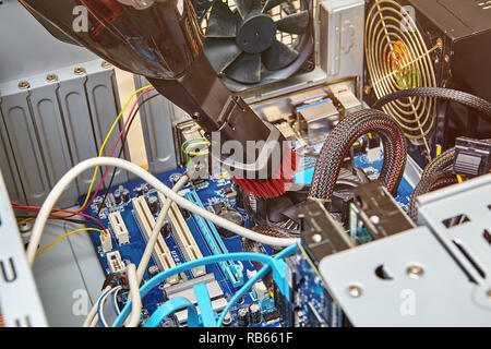 I cavi che sono collegati al disco rigido vicino alla scheda madre del computer desktop sono pulizia con aspirapolvere. Foto Stock