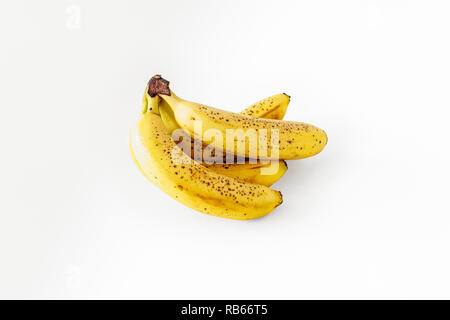 Un mazzetto di cinque leggermente surmature banane isolato su uno sfondo bianco Foto Stock