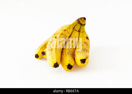 Un mazzetto di cinque leggermente surmature banane isolato su uno sfondo bianco Foto Stock