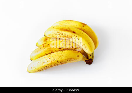 Un mazzetto di cinque leggermente surmature banane isolato su uno sfondo bianco Foto Stock